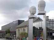 The art installation “Kopfbewegung - heads, shifting” graces Forumplatz on the Adlershof campus of Humboldt-Universität. The Erwin Schrödinger Center housing the science library can be seen in the background.