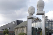 Die Kunstinstallation „Kopfbewegung - heads, shifting“ ziert den Forumsplatz auf dem Campus Adlershof der Humboldt-Universität. Im Hintergrund ist das das Erwin Schrödinger-Zentrum zu sehen, das die naturwissenschaftliche Bibliothek beherbergt.