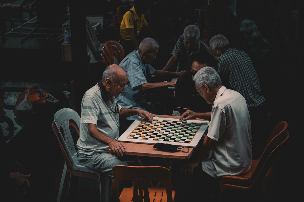 Ageing Well includes social interaction, like the two men playing a board game are demonstrate