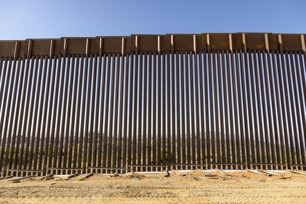 Liberalism is in a bind. Take places where populists beef up existing borders, as Donald Trump has done between Mexico and California. This image shows the border fence watched over by police.