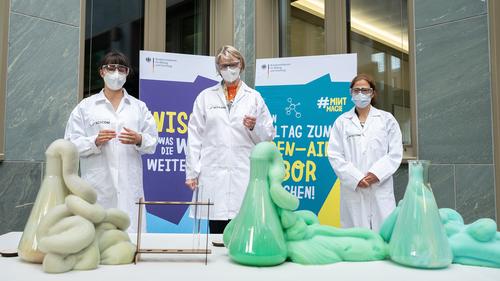Chemiestudentin Charlotte Gerischer (li) und Bundesforschungsministerin Anja Karliczek (Mitte) präsentieren gemeinsam anlässlich der Kampagne #MINTmagie das Vorführexperiment „Elefantenzahnpasta“.
