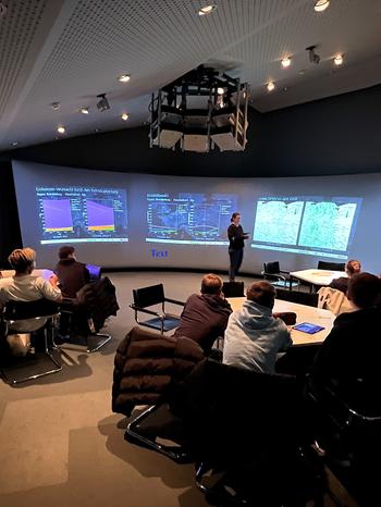 „Decision Theatre“ mit vier großen Bildschirmen. Hier werden die Auswirkungen der Maßnahmen-Entscheidungen nach den Gruppendiskussionen abgebildet, wie z.B. Emissionszunahme oder -reduzierung. © Beate Rogler / MATH+